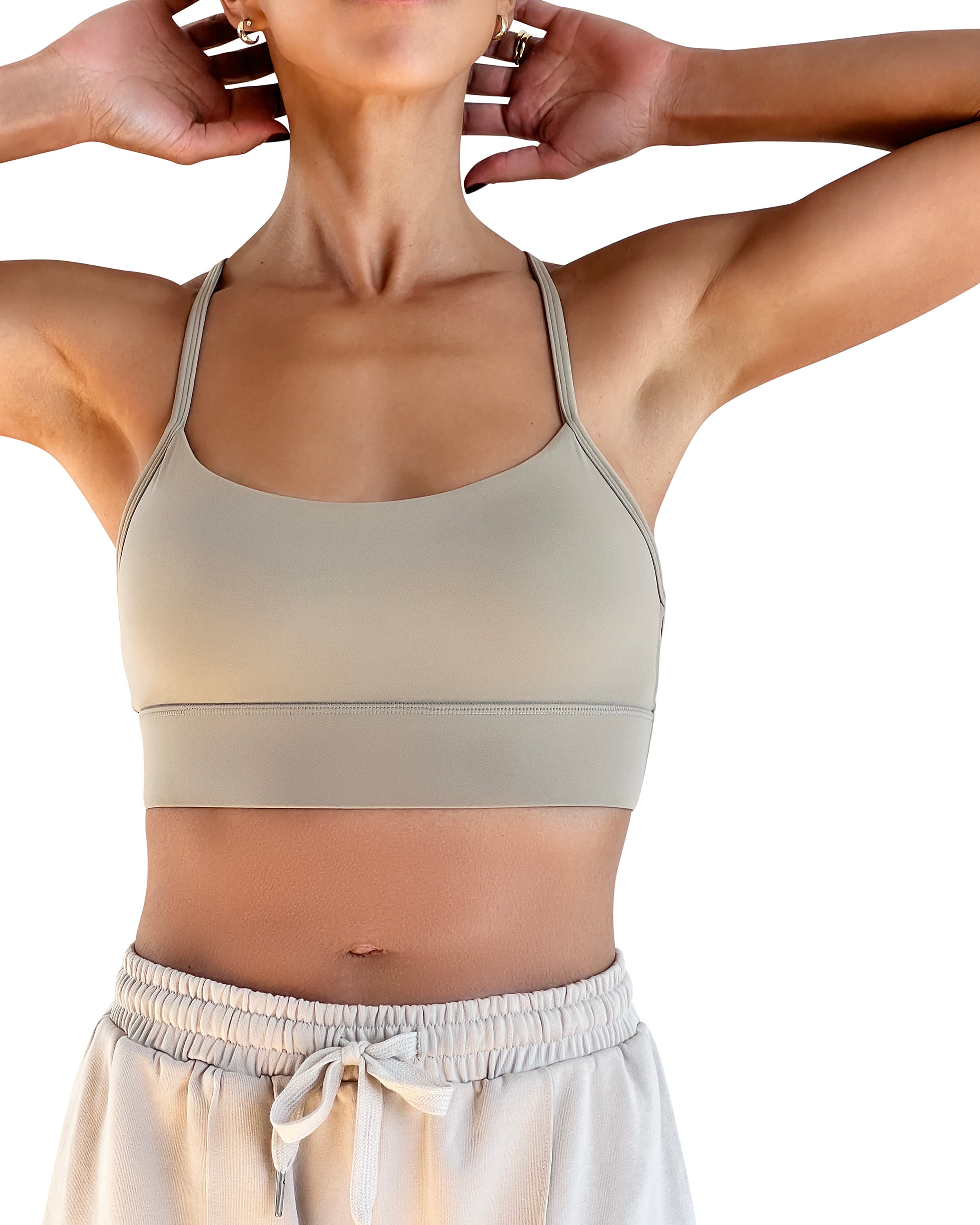 Beige cotton wide leg lounge pants with elastic waistband, side pockets and relaxed full-length fit, styled with a racerback sports bra for effortless athleisure wear.