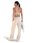 Beige cotton wide leg lounge pants with elastic waistband, side pockets and relaxed full-length fit, styled with a racerback sports bra for effortless athleisure wear.