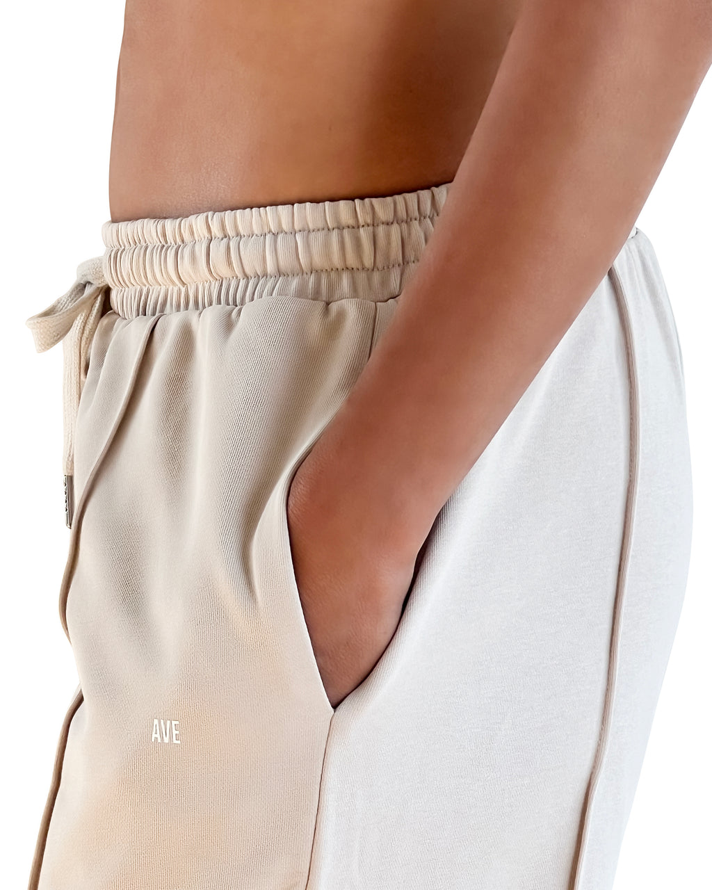 Beige cotton wide leg lounge pants with elastic waistband, side pockets and relaxed full-length fit for effortless athleisure wear.