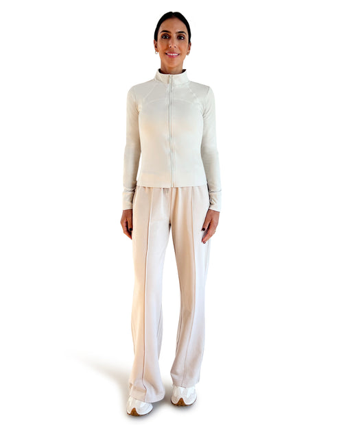 Beige cotton wide leg lounge pants with elastic waistband, side pockets and relaxed full-length fit, styled with a racerback sports bra for effortless athleisure wear.