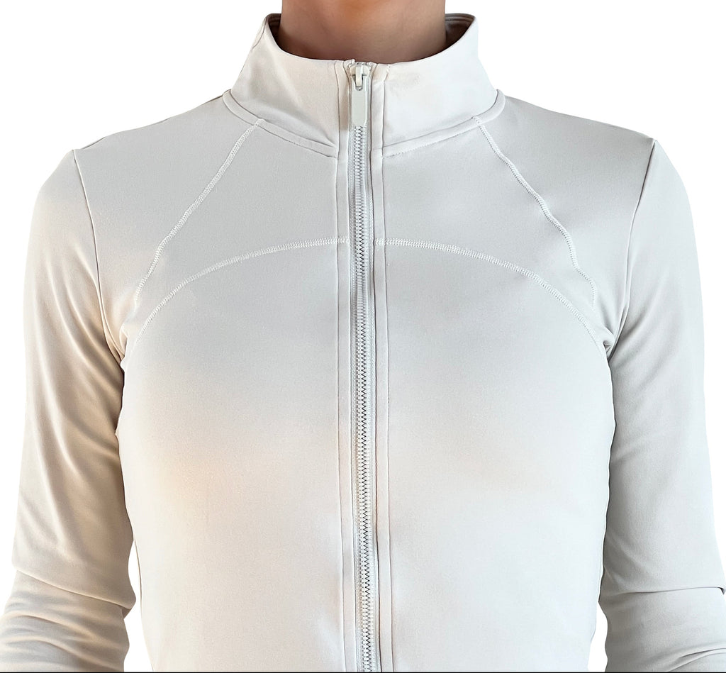 Women's ivory full-zip activewear jacket with thumbholes, four-way stretch fabric, and a flattering fitted silhouette for training, running, travel, and everyday wear.
