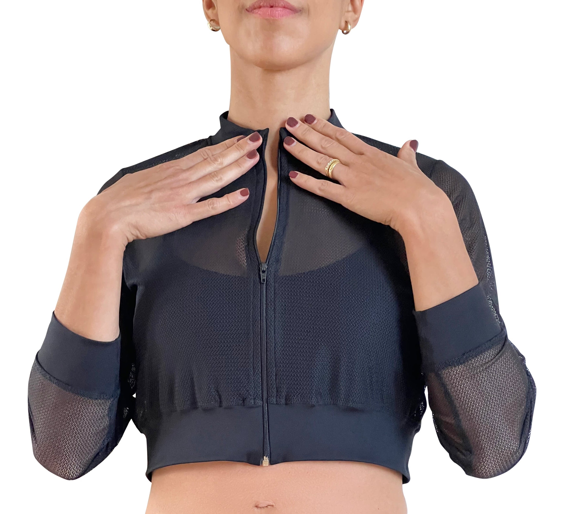 Woman in a black athletic outfit with mesh sleeves on a white background.