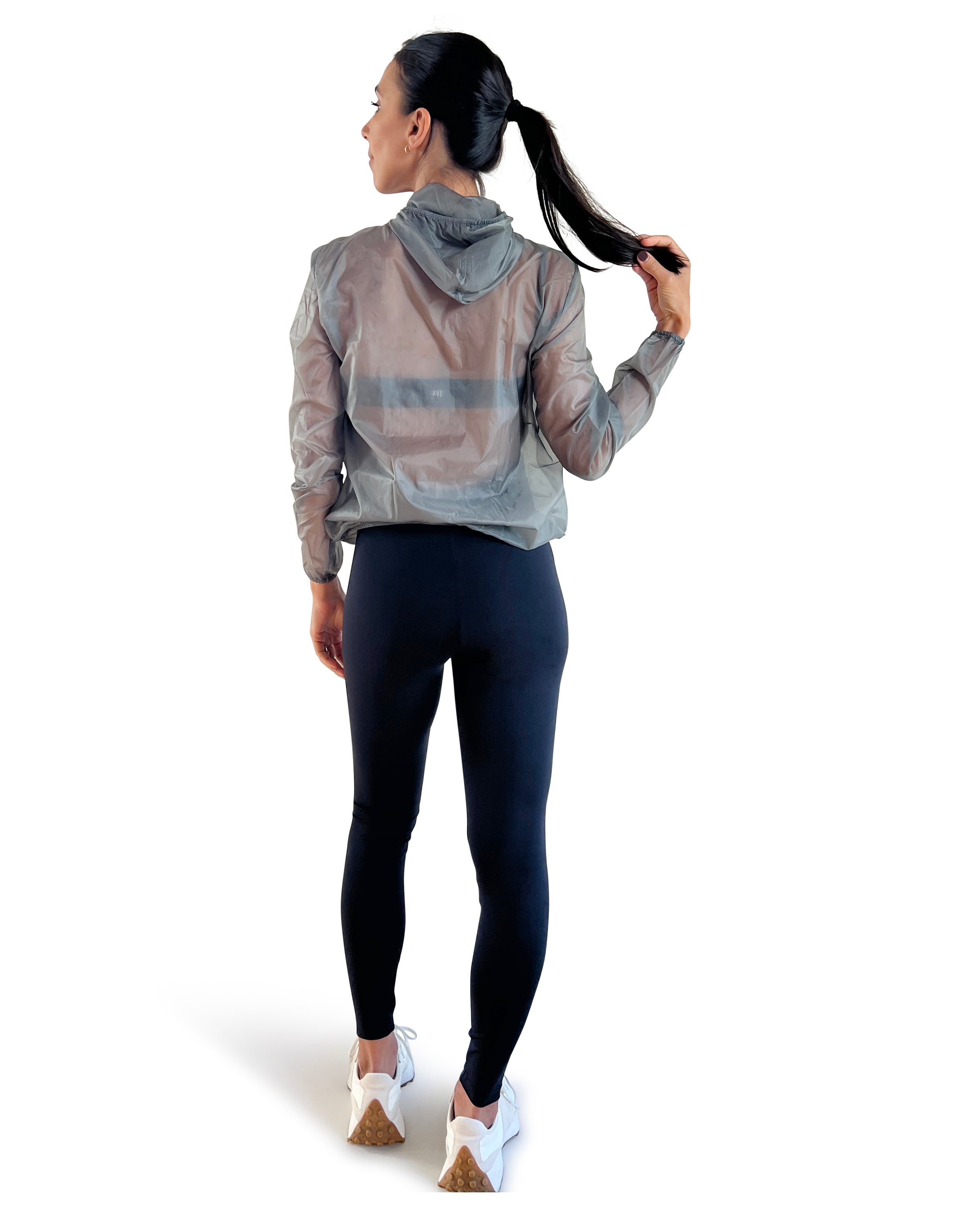 Women's grey lightweight windbreaker jacket with hood, breathable performance fabric, and packable design for travel, walking, and outdoor workouts.