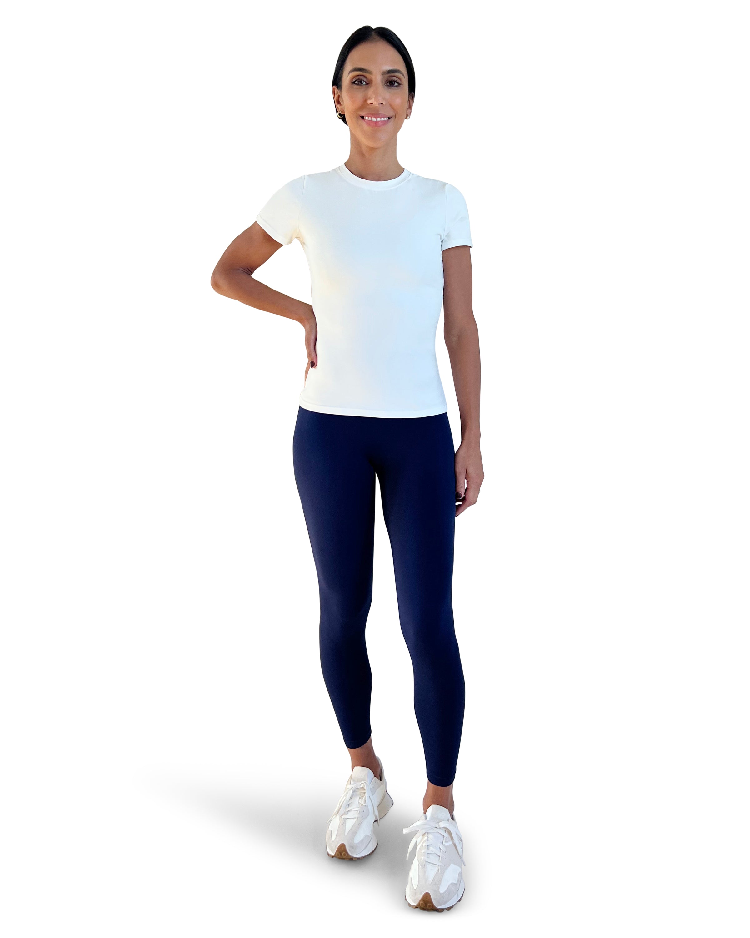 Woman wearing a white t-shirt and navy leggings on a white background for everyday wear.