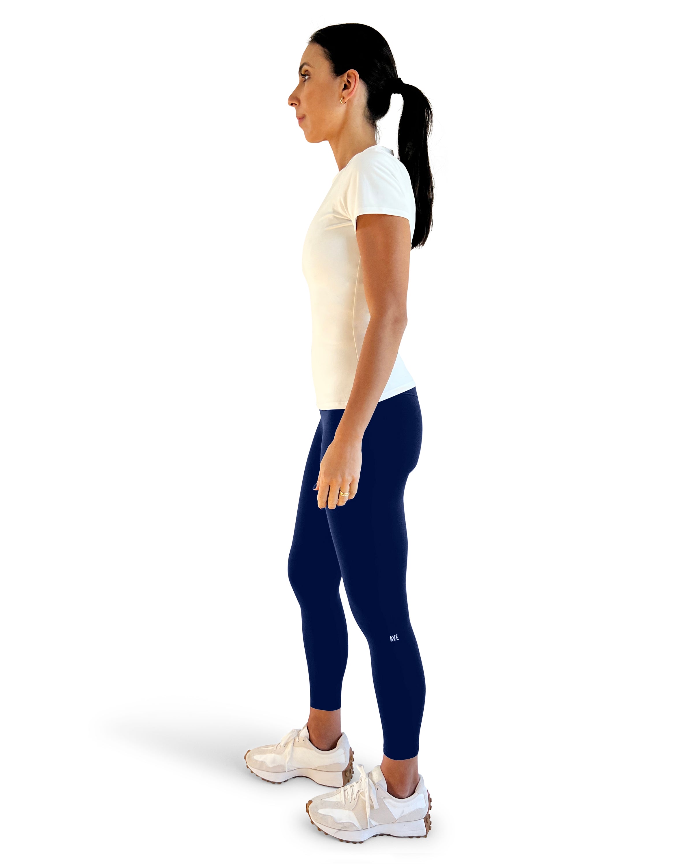 Woman wearing a white t-shirt and navy leggings on a white background for everyday wear.